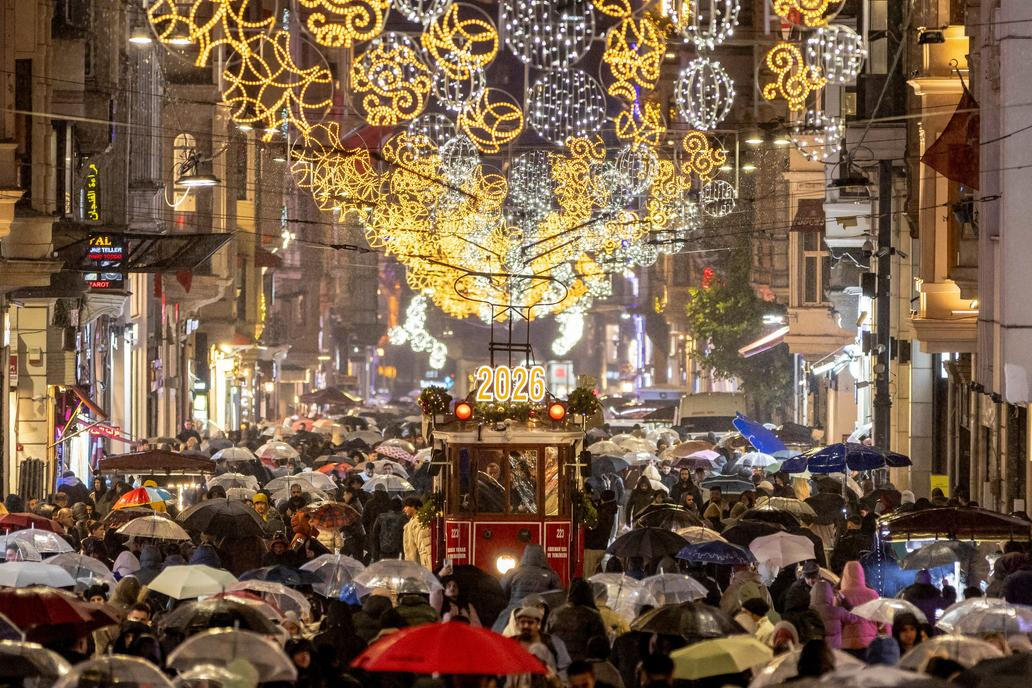 A vintage tram runs along Istiklal Street, decorated with New Year lighting, in central Istanbul