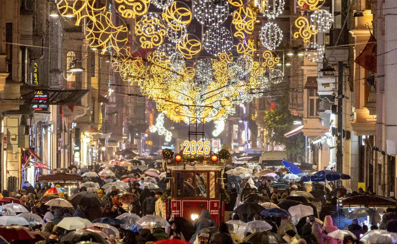 A vintage tram runs along Istiklal Street, decorated with New Year lighting, in central Istanbul