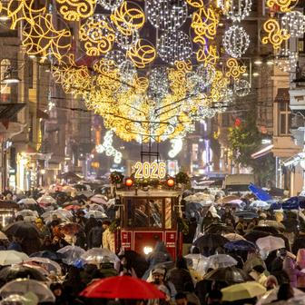 A vintage tram runs along Istiklal Street, decorated with New Year lighting, in central Istanbul