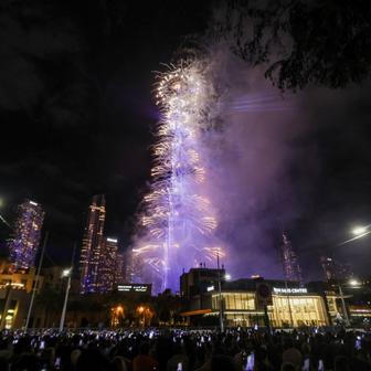 Lidé s mobily v rukou sledují novoroční ohňostroj v centru Dubaje.