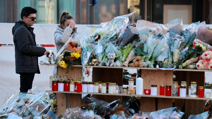 Lidé u provizorního pomníku ve švýcarském letovisku Crans-Montana vzdávají hold obětem tragického silvestrovského požáru v tamním baru Le Constellation; sobota 3. prosince 2026.