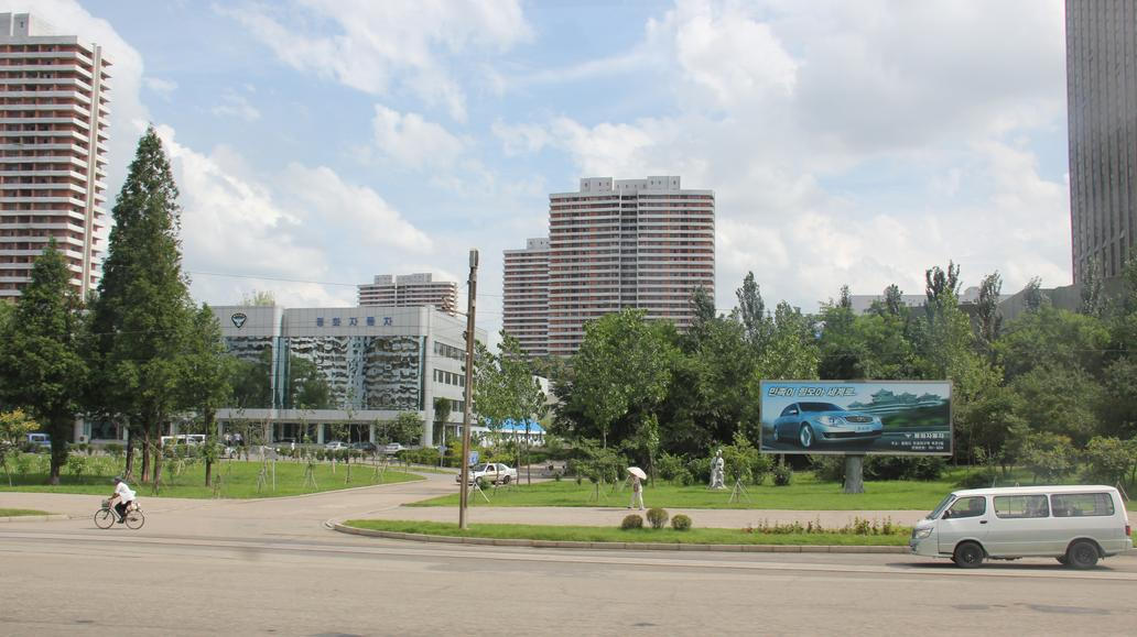 Zpráv o fungování automobilky Pyeonghwa (na billboardu model Hwiparam III, v pozadí showroom v Pchjongjangu) není mnoho, protože KLDR se po pandemii koronaviru izolovala více než obvykle. Podle posledních zpráv už v továrně ani auta nevznikají, místo nich zaujaly raketomety.