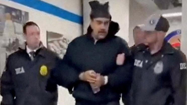 Spoutaného venezuelského prezidenta Nicoláse Madura vedou američtí agenti chodbou newyorského ústředí Úřadu pro potírání narkotik (DEA).