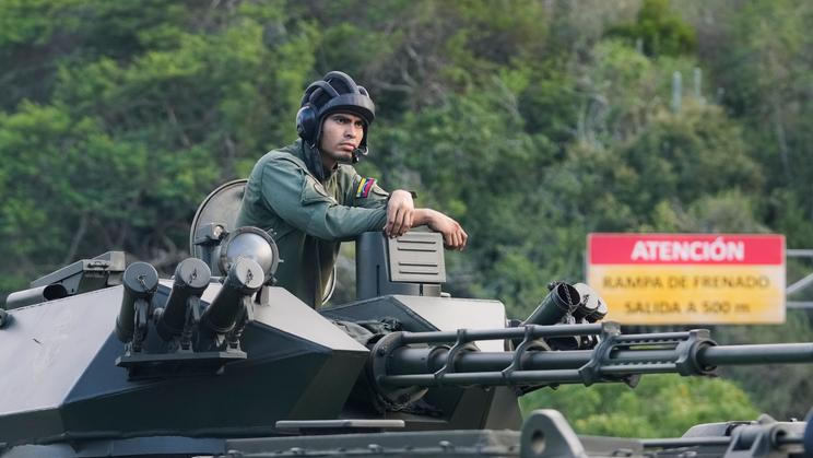 Venezuelský voják v obrněném transportéru hlídkuje v ulicích Caracasu; neděle 4. ledna 2026.