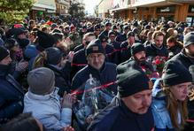 Na horním konci ulice, před barem Le Constellation, který je stále z velké části zakryt bílými zástěnami, se narůstající dav zastavil v téměř úplném tichu, někteří plakali.