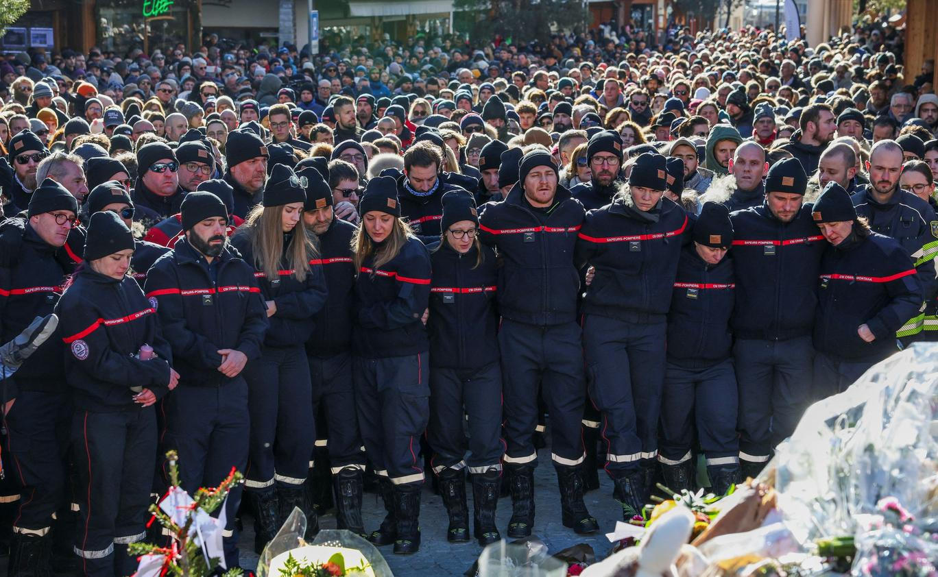 Na horním konci ulice, před vyhořelým barem Le Constellation, který je stále z velké části zakryt bílými zástěnami, se narůstající dav zastavil v téměř úplném tichu, někteří plakali.