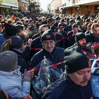 Na horním konci ulice, před barem Le Constellation, který je stále z velké části zakryt bílými zástěnami, se narůstající dav zastavil v téměř úplném tichu, někteří plakali.