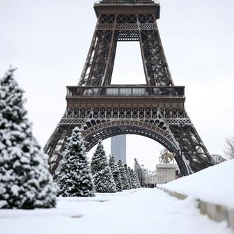 Pohled na zasněženou zem poblíž Eiffelovy věže v Paříži.