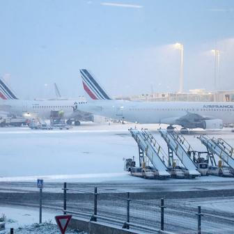 Pohled na letadla Air France na zasněženém letišti Charlese de Gaulla Paříž.