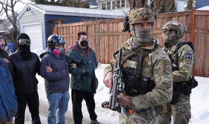 Maskovaní členové pohraniční stráže během středečního zásahu Úřadu pro imigraci a cla (ICE) v Minneapolisu, při níž byla zastřelena žena, která údajně najížděla do agentů nahánějících přistěhovalce. 