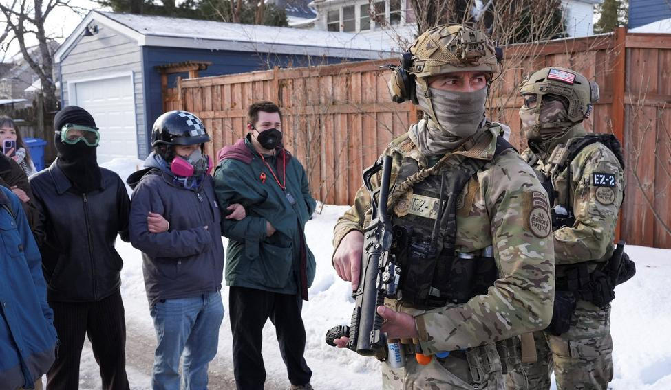 Maskovaní členové pohraniční stráže během středečního zásahu Úřadu pro imigraci a cla (ICE) v Minneapolisu, při níž byla zastřelena žena, která údajně najížděla do agentů nahánějících přistěhovalce. 
