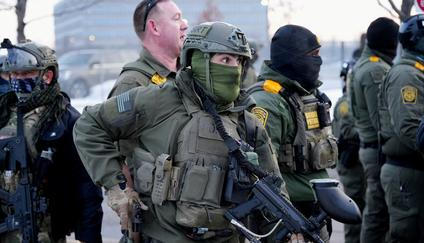 Člen takzvané speciální zásahové jednotky drží zbraně při protestu proti smrtelnému zastřelení Renee Nicole Goodové agentem americké imigrační a celní služby (ICE).