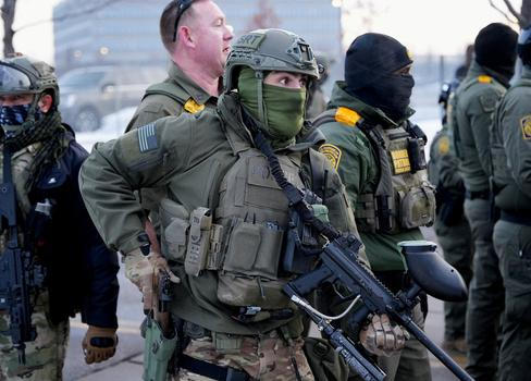 Člen takzvané speciální zásahové jednotky drží zbraně při protestu proti smrtelnému zastřelení Renee Nicole Goodové agentem americké imigrační a celní služby (ICE).