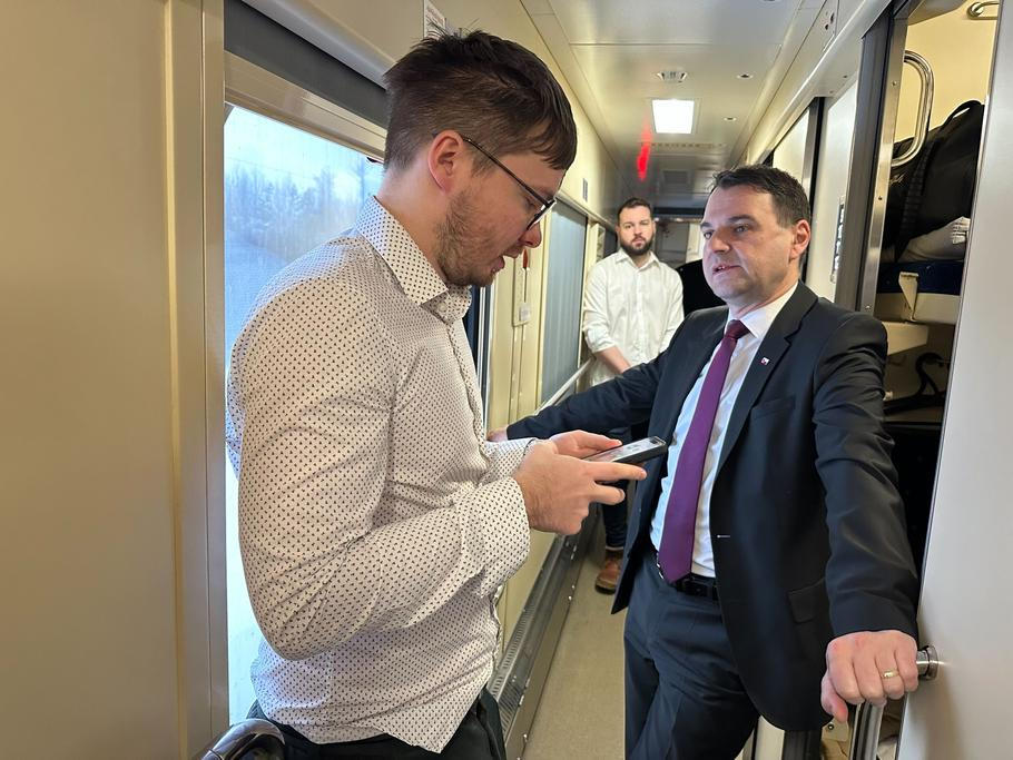 Ministr zahraničí Petr Macinka (vpravo) v pátek ráno ve vlaku do Kyjeva právě dostává od svého mluvčího Daniela Drakea informace, co se přes noc stalo, včetně nočního útoku ruských dronů a raket na Ukrajinu.