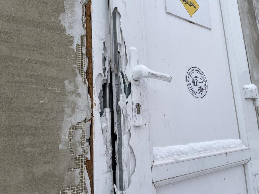 Bílé zásobovací dveře, kudy do restaurace U Kojota vnikli hasiči. Stopy po jejich páčidlech jsou dodnes jasně zřetelné.