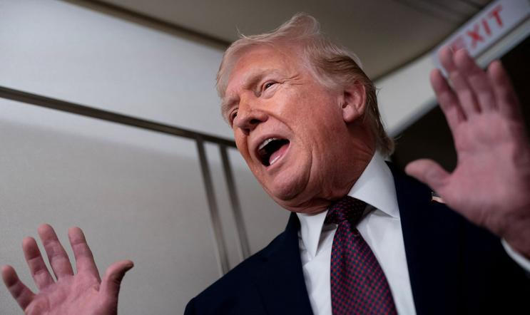 U.S. President Donald Trump speaks with members of the media aboard Air Force One en route to Joint Base Andrews