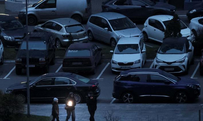 People use a flashlight as they walk during a power blackout in Kyiv