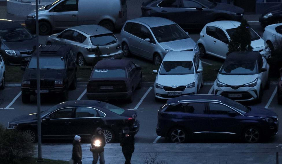 People use a flashlight as they walk during a power blackout in Kyiv