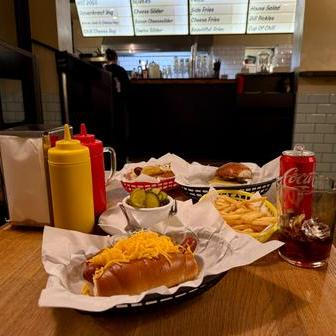 Kvalitní párek doplňuje sladká chuť slaninového džemu, hovězí slider je šťavnatý a chuťově vyvážený, hranolky jsou připraveny přesně tak akorát a nakládané okurky s koprem příjemně osvěžují a křupou.