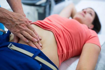 Woman getting ultrasound of a abdomen from doctor