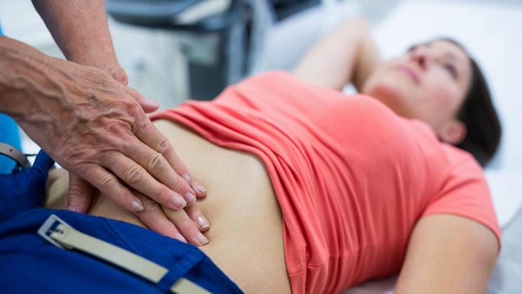 Woman getting ultrasound of a abdomen from doctor