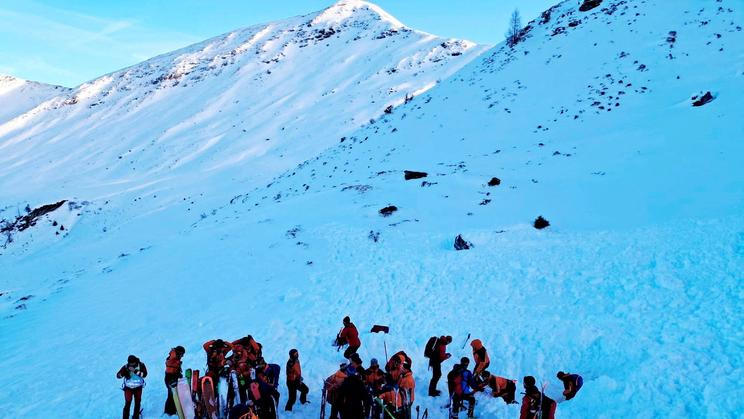 Rescue workers stand near the site where four skiers were killed in an avalanche in Pongau district