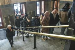 Městská knihovna v Praze a turisté čekající ve frontě na fotku se sloupem z knih kvůli jeho popularitě na sociálních sítích.