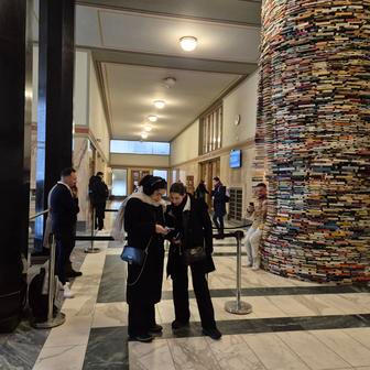 Pro snímek s instalací Idiom turisté neváhají se na umělecké dílo i posadit. "Sloup vědění" se proto letos musí celý rozebrat a sestavit z knih nových. Dříve se socha opravovala zhruba jednou za sedm let, dnes už to nestačí.