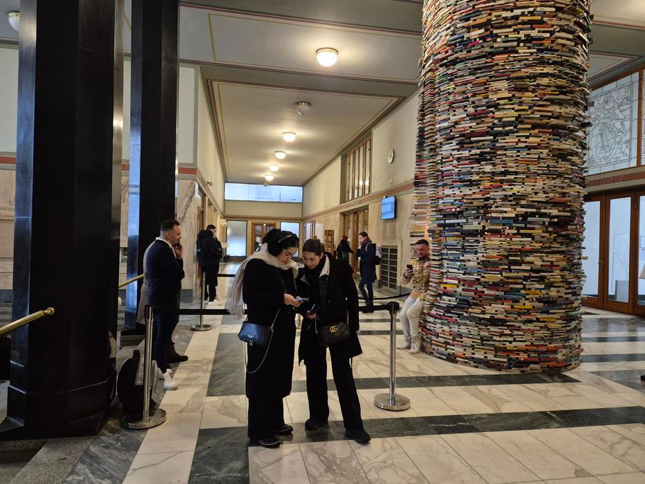 Pro snímek s instalací Idiom turisté neváhají se na umělecké dílo i posadit. "Sloup vědění" se proto letos musí celý rozebrat a sestavit z knih nových. Dříve se socha opravovala zhruba jednou za sedm let, dnes už to nestačí.