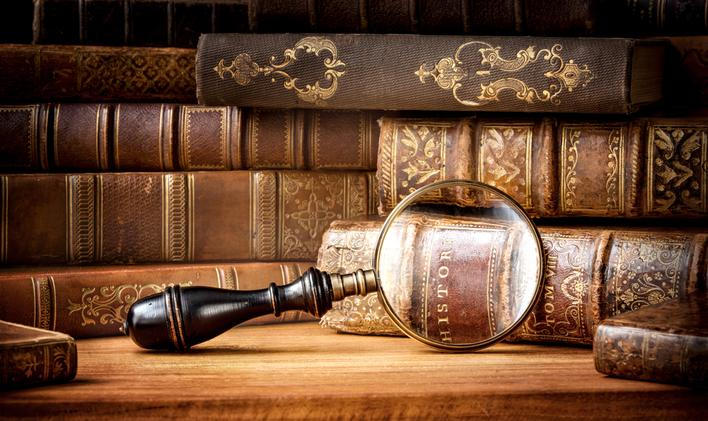 Old,Books,And,Antique,Magnifying,Glass,On,A,Wooden,Background.