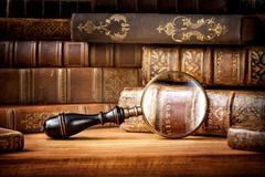 Old,Books,And,Antique,Magnifying,Glass,On,A,Wooden,Background.