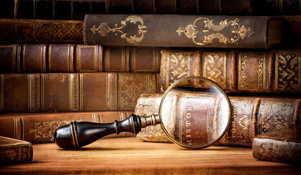 Old,Books,And,Antique,Magnifying,Glass,On,A,Wooden,Background.