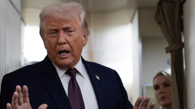 FILE PHOTO: U.S. President Donald Trump speaks to reporters aboard Air Force One