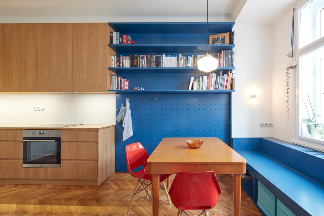 Největší místnost bytu propojuje kuchyň, jídelnu a obývací část do jednoho plynulého celku. Vestavný nábytek je řešen kolážovitě – lakovaná MDF zde nakombinovali s dubovou dýhou, což interiér odlehčuje a dodává mu osobitý charakter.