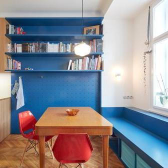 Největší místnost bytu propojuje kuchyň, jídelnu a obývací část do jednoho plynulého celku. Vestavný nábytek je řešen kolážovitě – lakovaná MDF zde nakombinovali s dubovou dýhou, což interiér odlehčuje a dodává mu osobitý charakter.