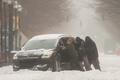 A group of men try to help a stuck motorist in the snow while the multi-state Winter Storm Fern hits the metro area of Louisville