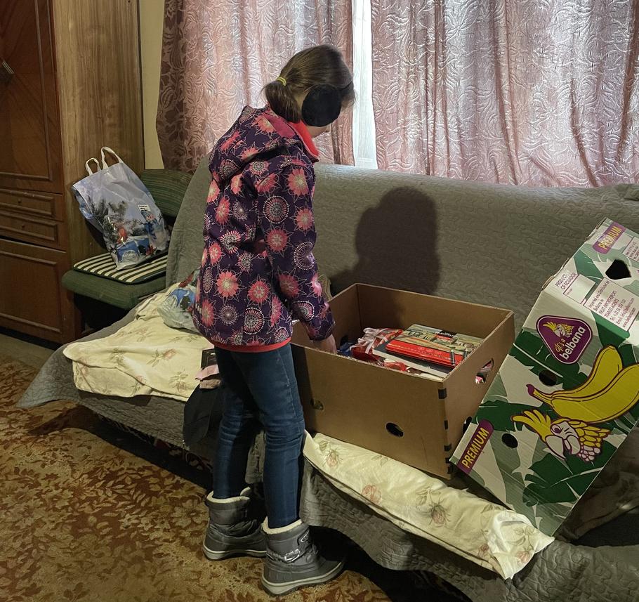 Malá Táňa rozbaluje vánoční dárky od patrona z Česka.