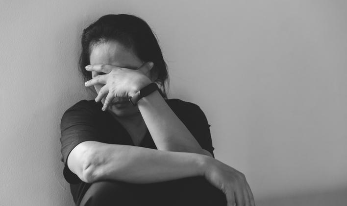 Young depressed woman, domestic and rape violence, beaten and raped sitting in the corner. Female fear and depression from domestic violence.