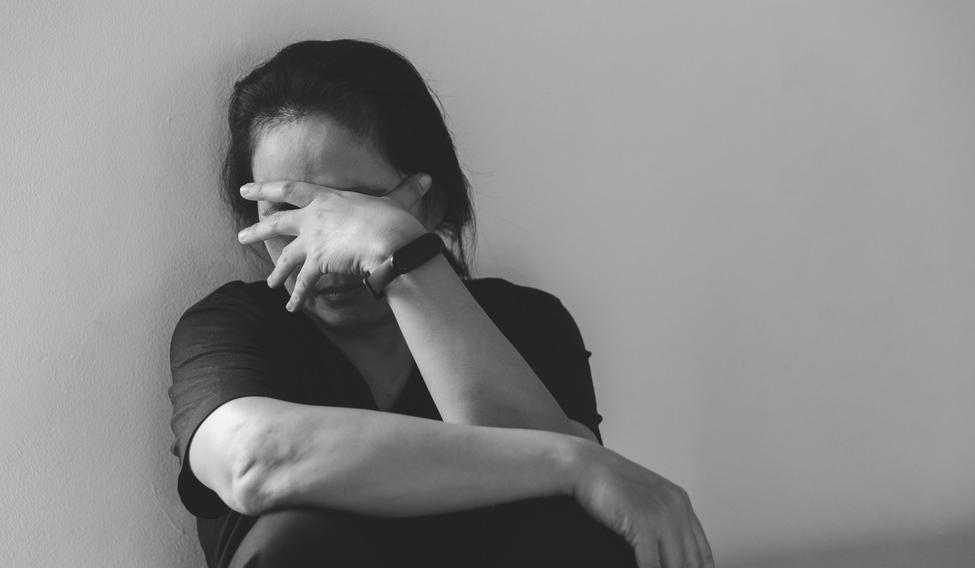 Young depressed woman, domestic and rape violence, beaten and raped sitting in the corner. Female fear and depression from domestic violence.