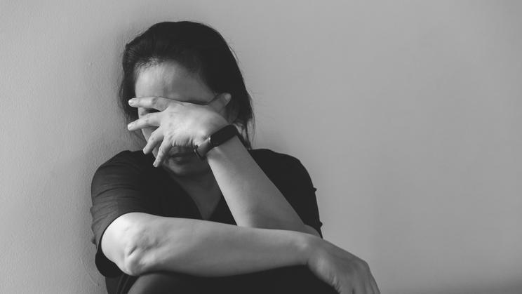 Young depressed woman, domestic and rape violence, beaten and raped sitting in the corner. Female fear and depression from domestic violence.