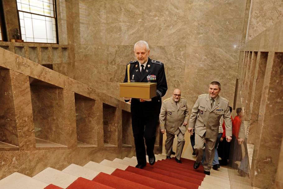 Zástupci prezidentské kanceláře předávají zástupcům armádního muzea téměř 110 let starý český prapor