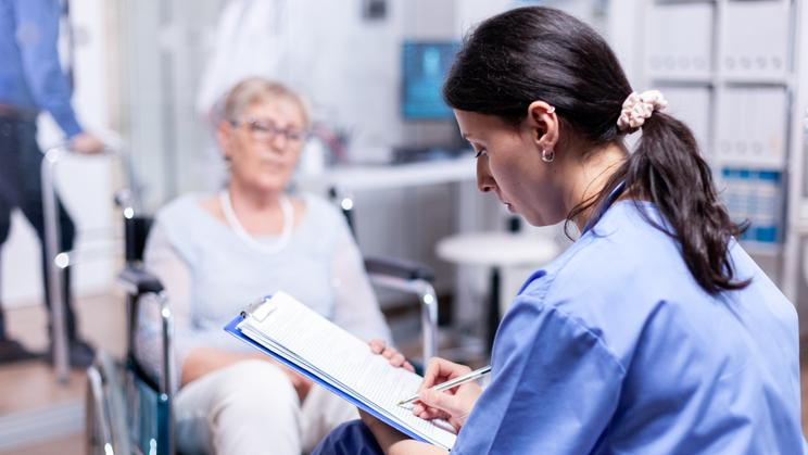 ["Nurse writing on clipboard"]