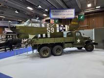 Vojenský nákladní automobil GMC s letadlem v zadní části.