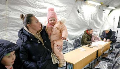 Obyvatelé se zahřívají ve stanu humanitárního centra provozovaného vládou, kde si mohou nabít své elektronické přístroje, dostat teplé jídlo, pití a psychologickou podporu. Stan byl postaven vedle bytových domů během výpadku elektřiny poté, co byla kritická občanská infrastruktura zasažena nedávnými ruskými raketovými a dronovými útoky v rámci ruské invaze na Ukrajinu, Kyjev, Ukrajina, 25. ledna 2026.