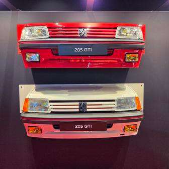 Přední část 205 GTI před (bílá) a po faceliftu.