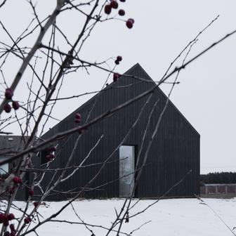 Výrazným znakem stavby je zcela jistě černá fasáda z opalovaných prken sibiřského modřínu, zpracovaná tradiční japonskou technikou. Ta není pouze estetickým gestem, ale především funkčním řešením s vysokou životností. „Nejde jen o barvu. Opalované dřevo je výrazně odolnější vůči povětrnostním vlivům i škůdcům. Je to stará japonská technika konzervace dřeva, tady provedená strojně,“ vysvětluje Janout.