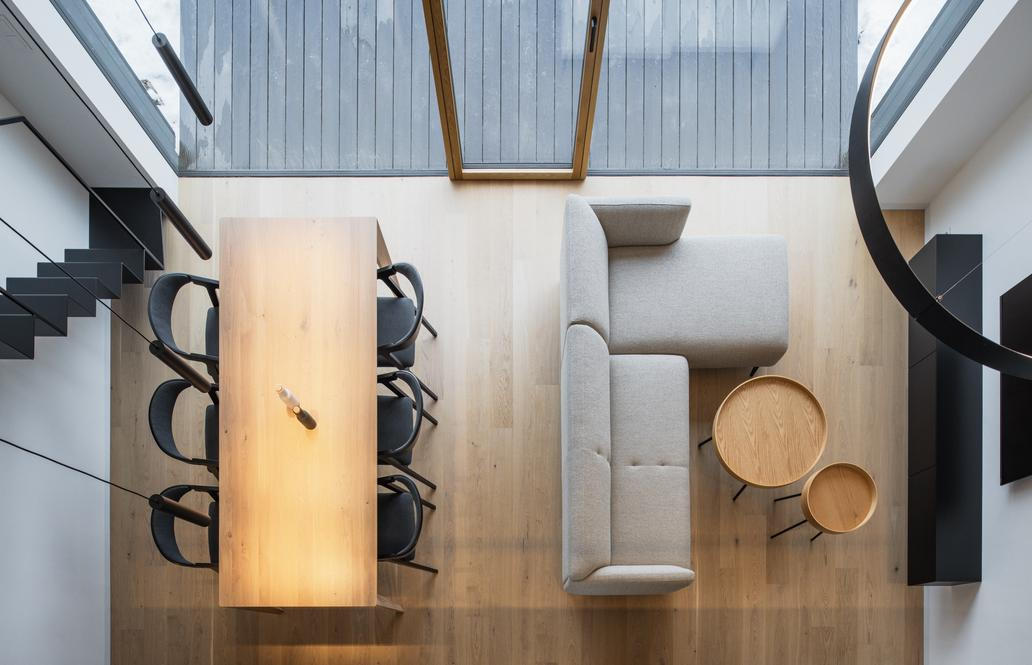 Centrem domu je obytný prostor s kuchyní, jídelnou a obývacím pokojem, otevřený do krovu s přiznanými dřevěnými stropnicemi –⁠⁠⁠⁠⁠⁠ volba dřevěné konstrukce umožnila lehkou střešní skladbou. 