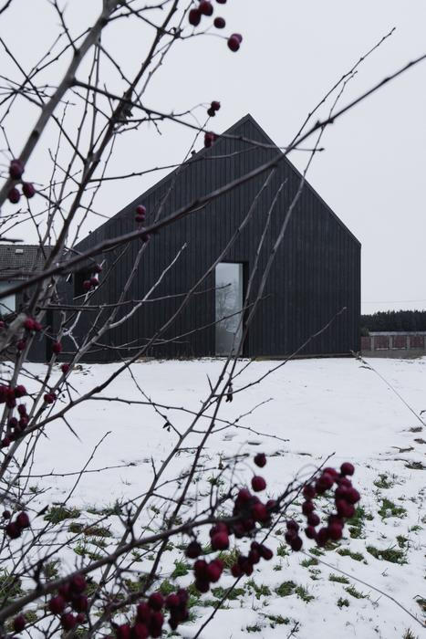 Výrazným znakem stavby je zcela jistě černá fasáda z opalovaných prken sibiřského modřínu, zpracovaná tradiční japonskou technikou. Ta není pouze estetickým gestem, ale především funkčním řešením s vysokou životností. „Nejde jen o barvu. Opalované dřevo je výrazně odolnější vůči povětrnostním vlivům i škůdcům. Je to stará japonská technika konzervace dřeva, tady provedená strojně,“ vysvětluje Janout.