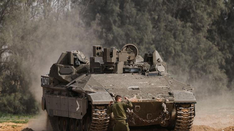 An Israeli soldier directs an APC close to the southern part of the Gaza Strip, near Kerem Shalom crossing