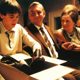 Miroslav Donutil jako otec Šebek, Simona Stašová coby jeho manželka a Michael Beran v roli jejich syna v legendární komedii Pelíšky.